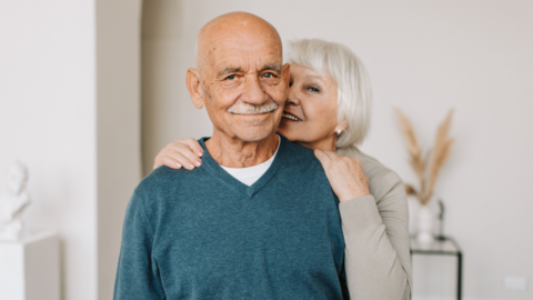 ouder echtpaar, vrouw staat achter man